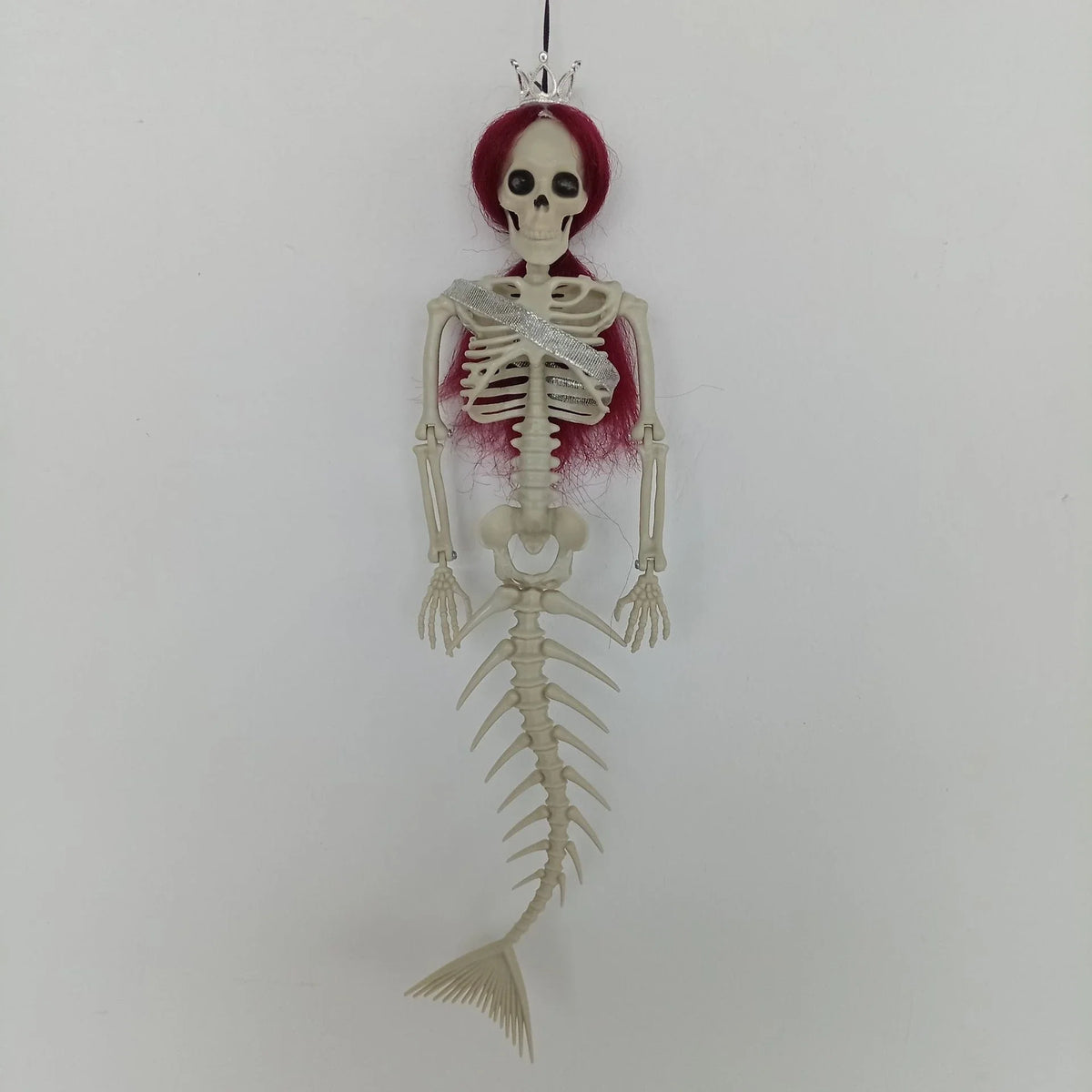 Mermaid bone pendant in various colors, including brown, dark purple, burgundy, and lake blue, hanging outdoors for Halloween decoration
