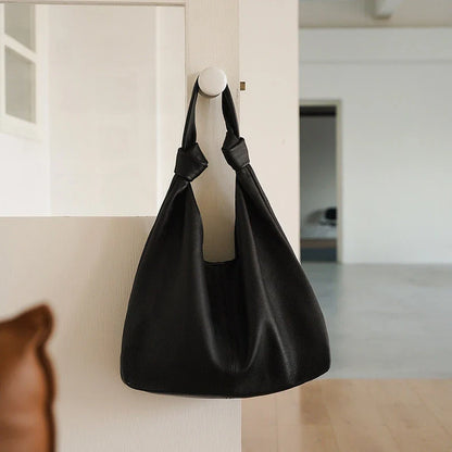 Luxurious oversized genuine leather hobo shoulder bag in black, featuring a spacious interior, multiple compartments, and a soft, flexible design for everyday use.