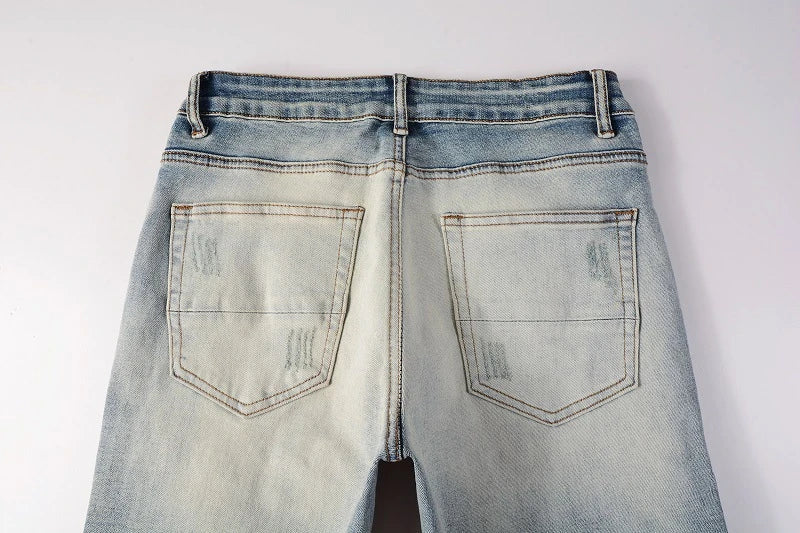 American High Street fashionable men's ripped black and white patch jeans in a light blue denim color