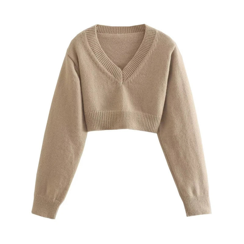 A cozy, knitted pullover sweater with a timeless round neck design, available in a versatile camel color.
