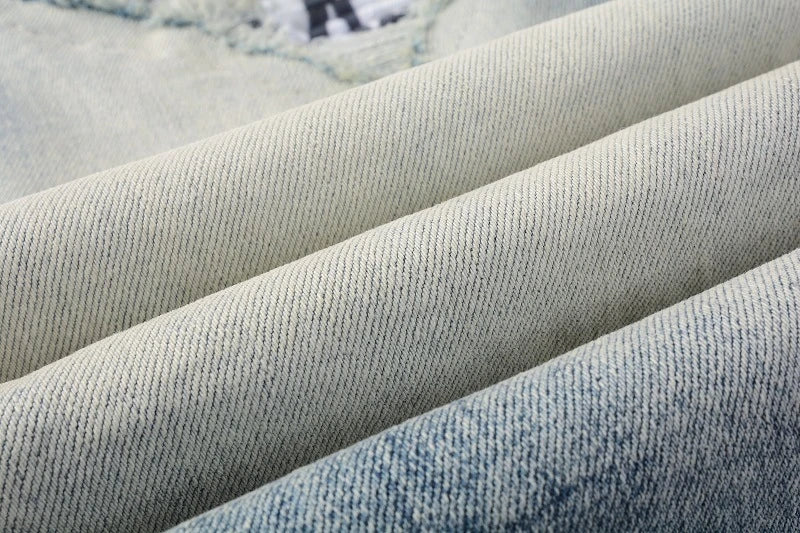 American High Street fashionable men's ripped black and white patch jeans in a light blue denim color