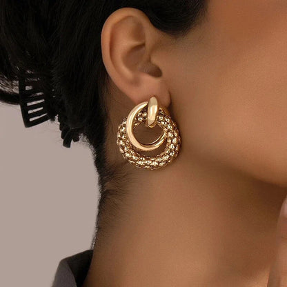 Elegant gold-toned twist dangle earrings with an intricate geometric design, perfect for adding a touch of sophistication to any outfit.