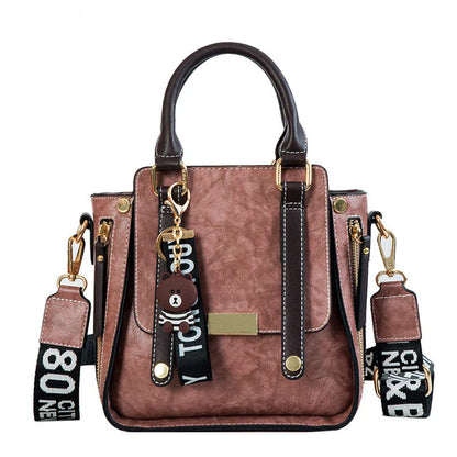 Fashionable wide shoulder strap shoulder bag in pink color with square vertical design and multiple interior pockets