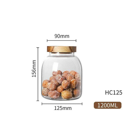 Airtight glass food storage jars with wooden lids in various sizes, perfect for organizing and preserving dry goods, spices, and pantry items in the kitchen.