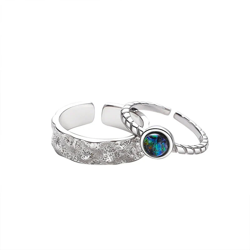 A sterling silver couple's ring set featuring a captivating glass design and an adjustable fit