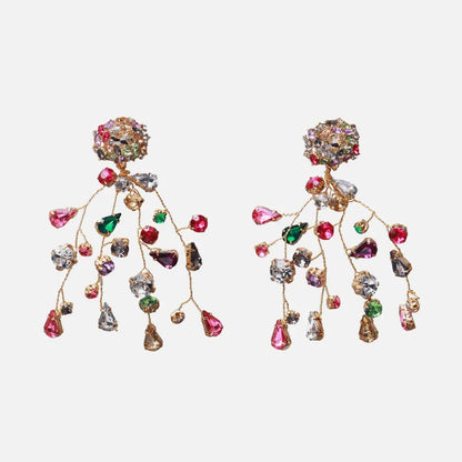 Closeup of a pair of colorful diamond and crystal earrings with a vibrant, retro-inspired design
