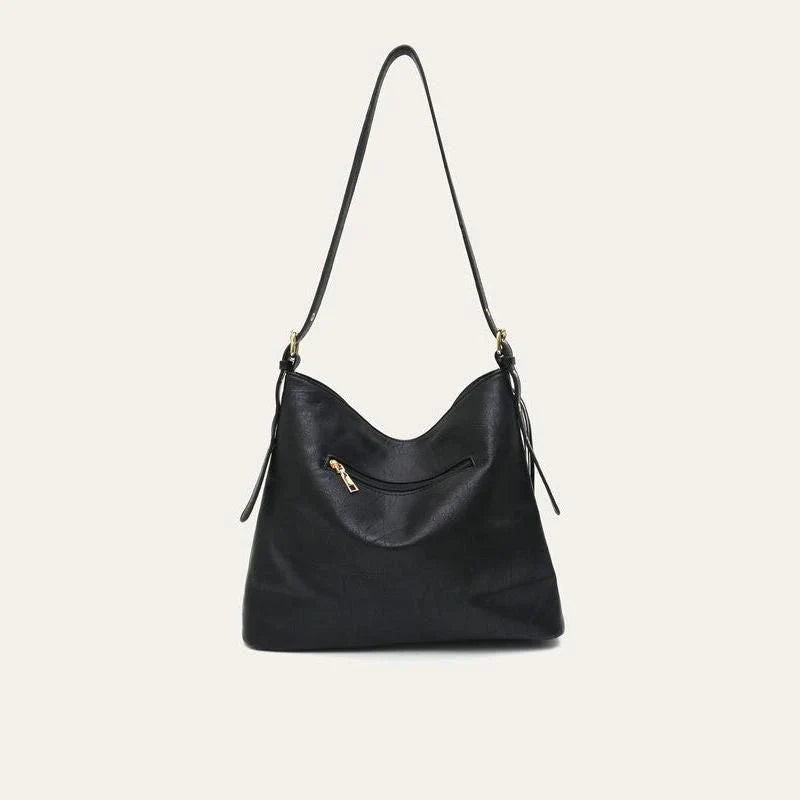 Chic vegan leather shoulder bag with tassel decoration, featuring a spacious interior and versatile carrying options