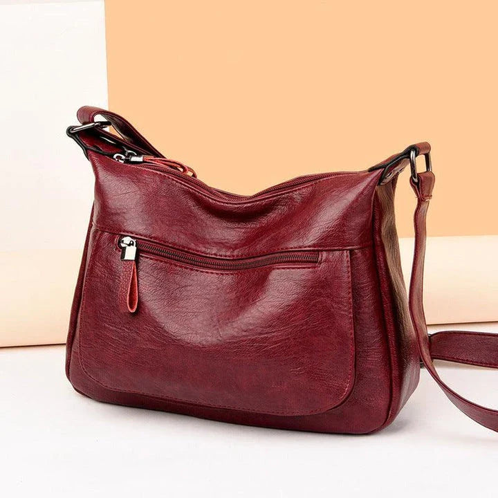 Stylish one-shoulder messenger bag in various colors with a soft, supple PU leather exterior and a spacious, organized main compartment