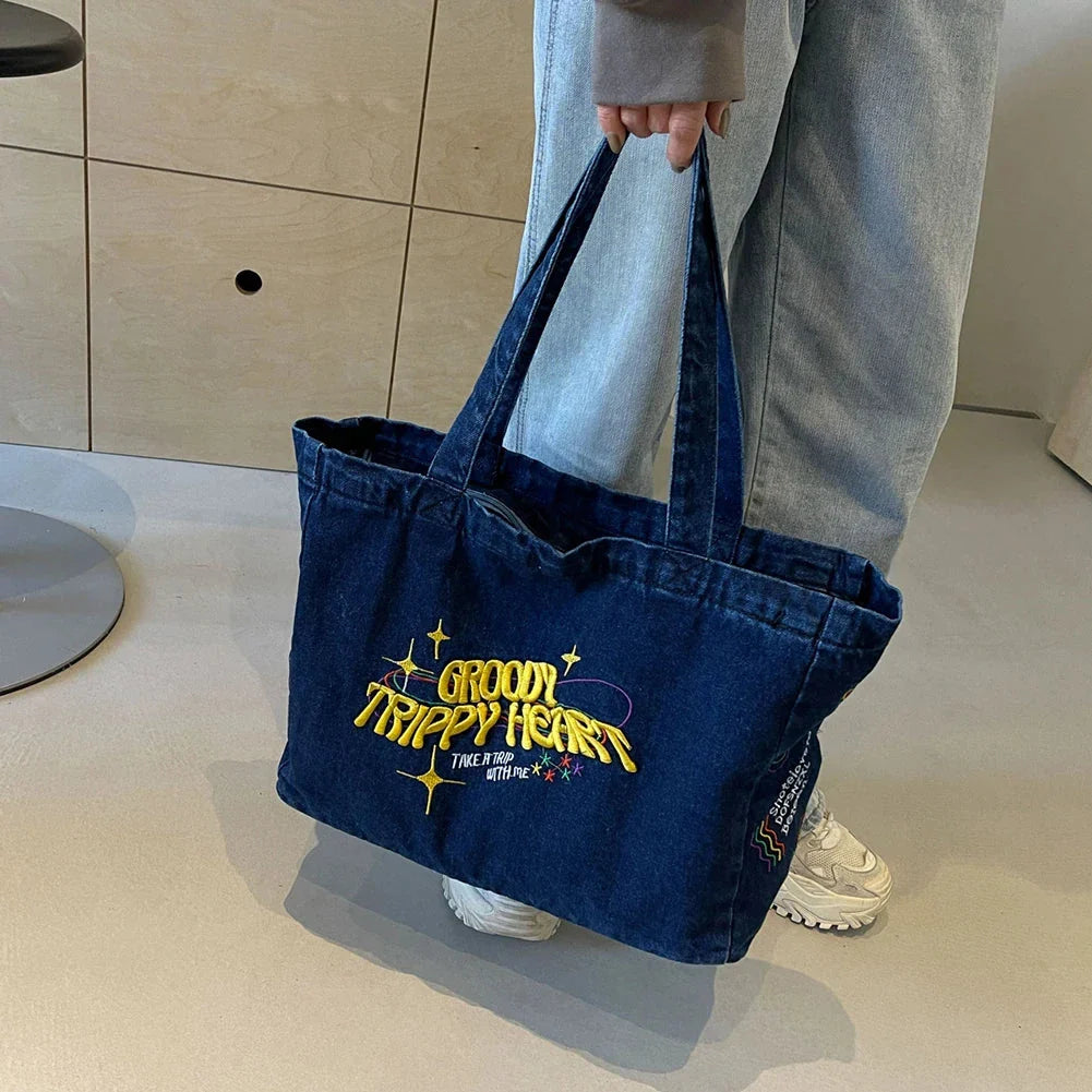 A stylish denim shoulder bag with embroidered details, perfect for everyday use and carrying all your essentials