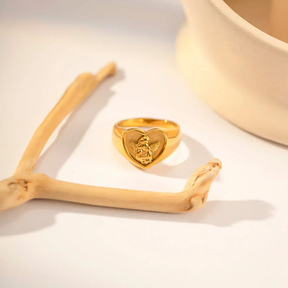 Sophisticated gold-plated stainless steel ring with a geometric heart and angel design, perfect for adding a touch of elegance to any outfit.