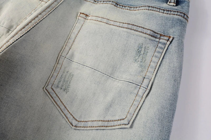 American High Street fashionable men's ripped black and white patch jeans in a light blue denim color