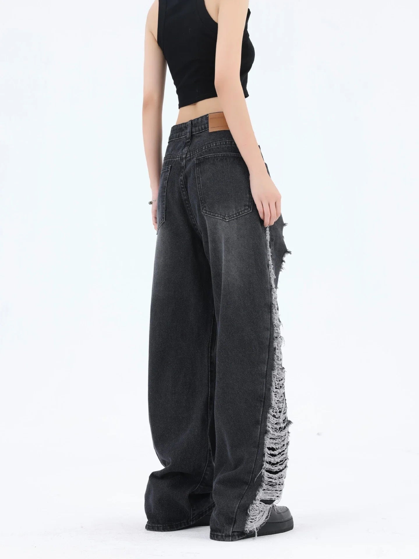 Premium loose fit distressed denim trousers for men and women, featuring a relaxed silhouette, high-quality cotton construction, and trendy distressed details.