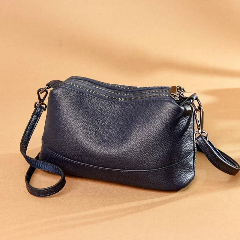 Cowhide shoulder bag in various colors, featuring a sleek and modern design with multiple internal pockets for organization.