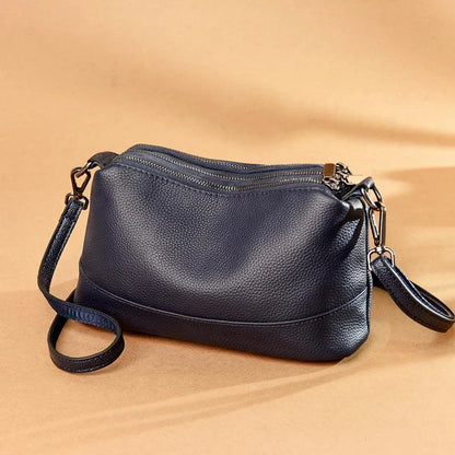 Cowhide shoulder bag in various colors, featuring a sleek and modern design with multiple internal pockets for organization.