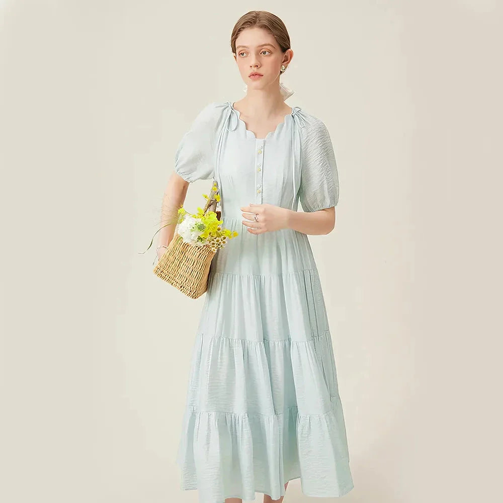 A chic, French-inspired summer dress with an empire waistline, V-neck, and A-line silhouette, perfect for seaside elegance.