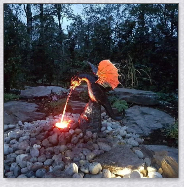 Precision-crafted fire-breathing dragon sculpture serving as a captivating water feature in a lush garden setting