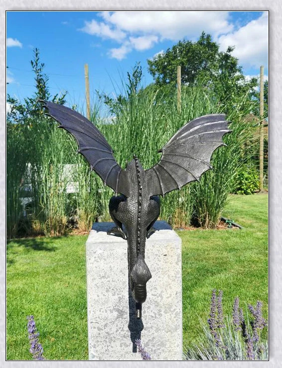 Precision-crafted fire-breathing dragon sculpture serving as a captivating water feature in a lush garden setting