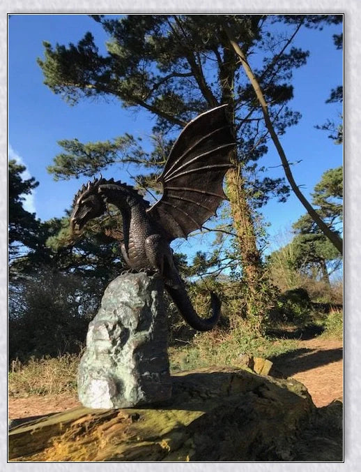 Precision-crafted fire-breathing dragon sculpture serving as a captivating water feature in a lush garden setting
