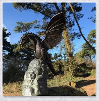 Precision-crafted fire-breathing dragon sculpture serving as a captivating water feature in a lush garden setting