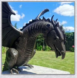 Precision-crafted fire-breathing dragon sculpture serving as a captivating water feature in a lush garden setting