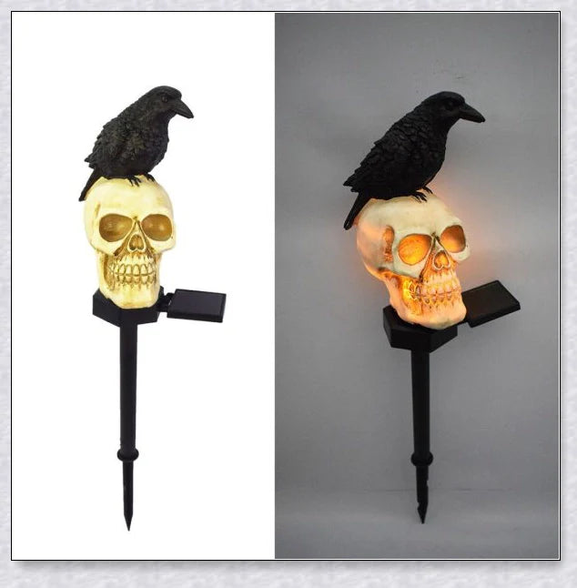 A solar-powered landscape light in the shape of a crow perched on a skull, providing an eerie and captivating outdoor decoration.