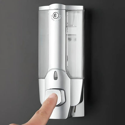 A modern, silver-colored 350ml wall-mounted soap and shampoo dispenser with a sleek, touch-free design for enhanced hygiene in bathrooms and kitchens.