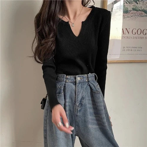 Woman wearing a brown knitted long-sleeved v-neck shirt in a casual, stylish outfit