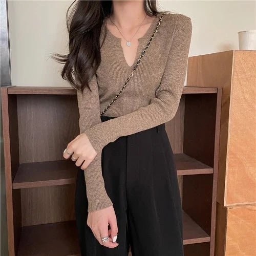 Woman wearing a brown knitted long-sleeved v-neck shirt in a casual, stylish outfit