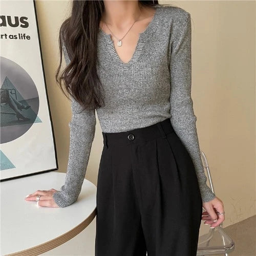 Woman wearing a brown knitted long-sleeved v-neck shirt in a casual, stylish outfit