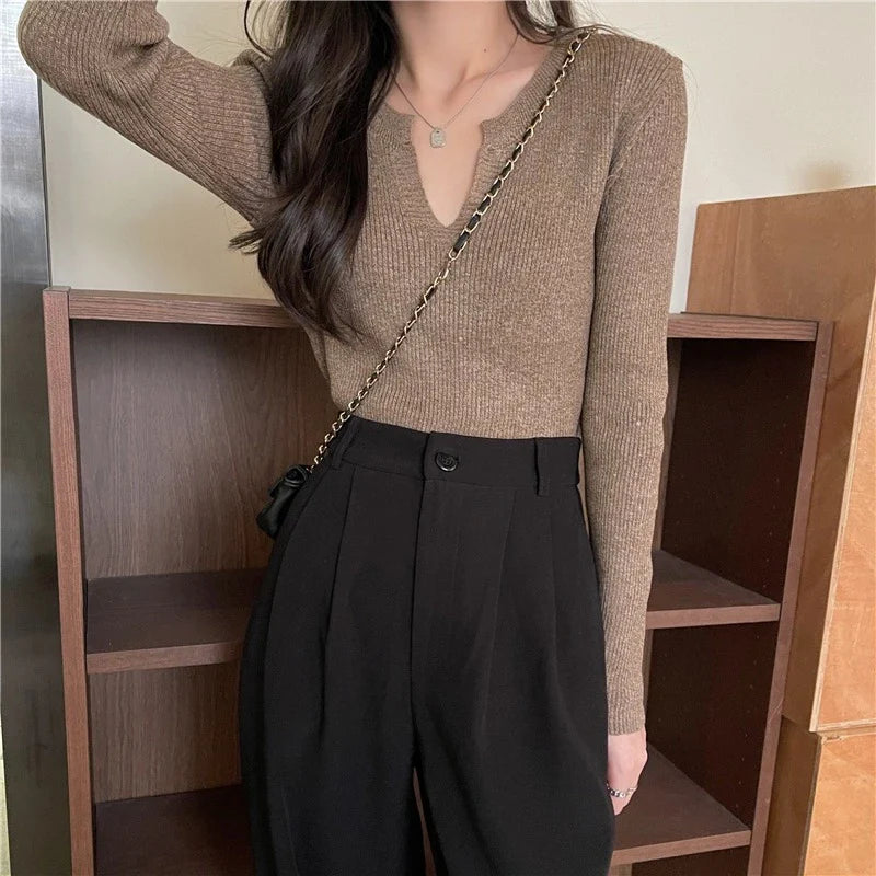 Woman wearing a brown knitted long-sleeved v-neck shirt in a casual, stylish outfit