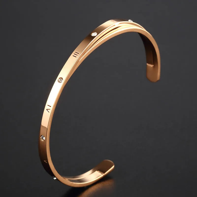 Women's open-ended stainless steel bracelet with a central inlaid zircon stone in rose gold colour.