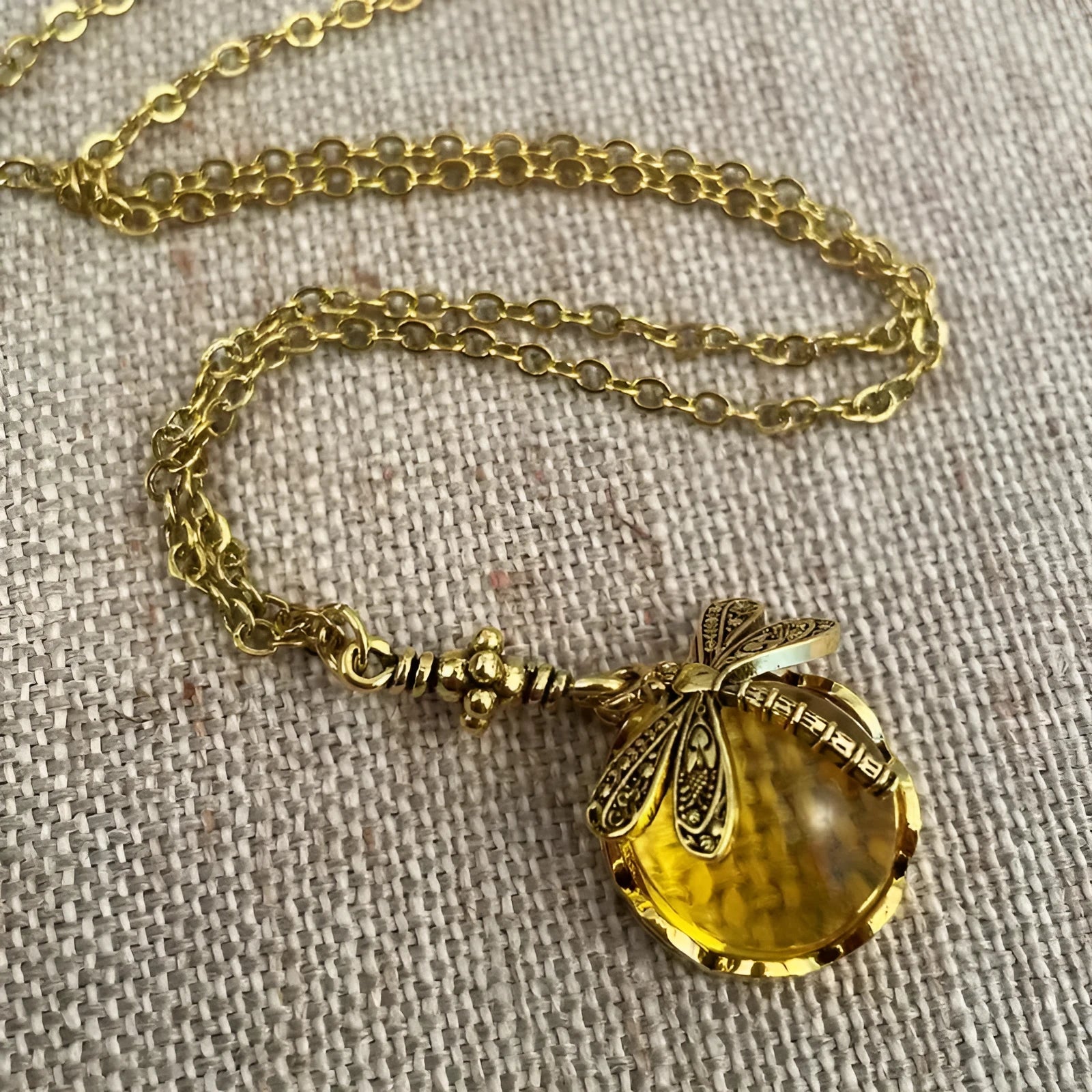 Vintage bronze dragonfly pendant necklace on a chain, yellow finish, pastoral style.