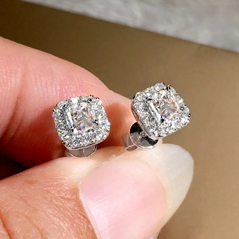 A pair of bright green square zircon stud earrings with a gold electroplated setting on a white background.