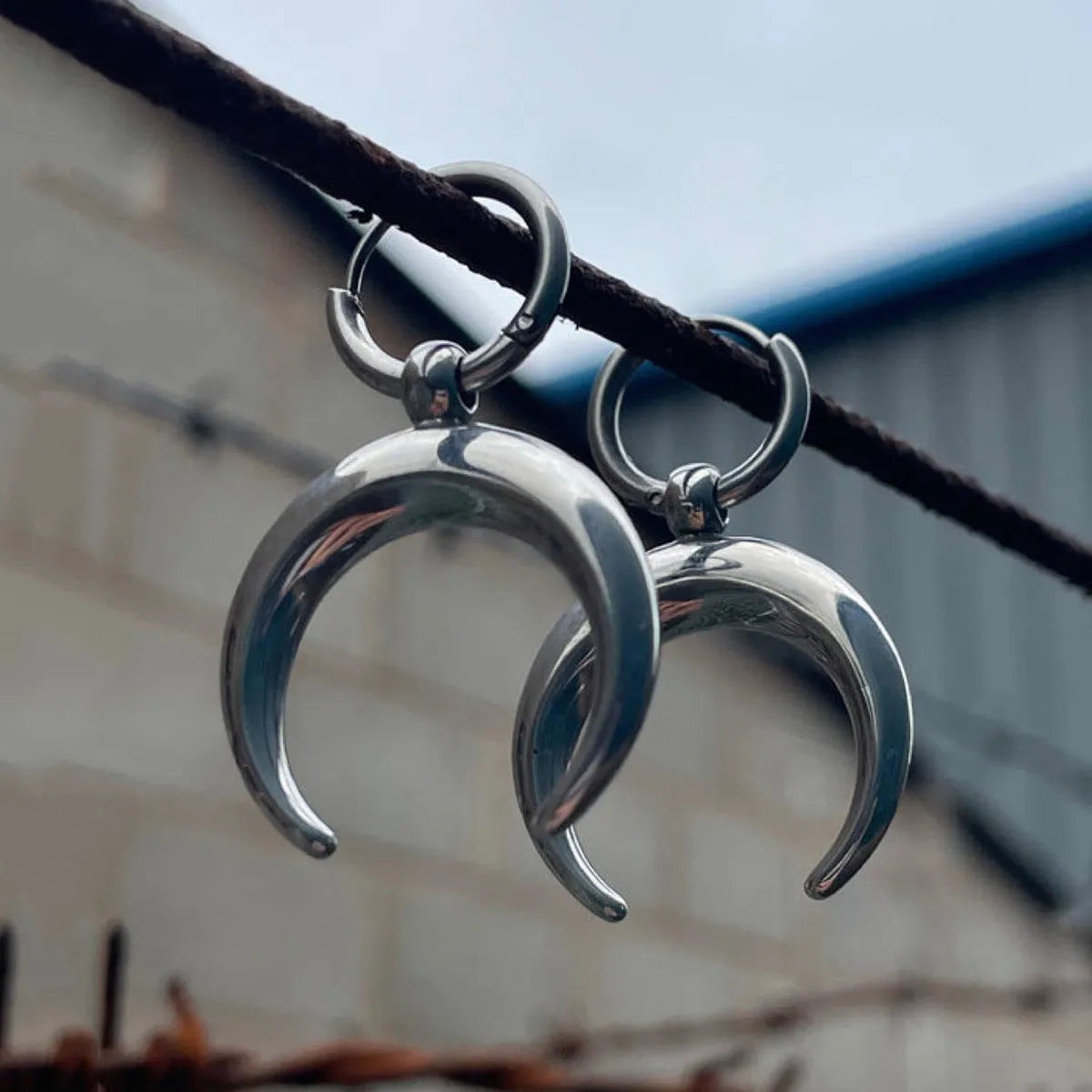 Silver big hoop earrings with a gothic moon and geometric punk design, ear clip style.