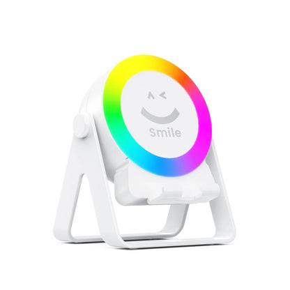 Black and white wireless induction charging Bluetooth speaker with colourful LED lights on a desk.