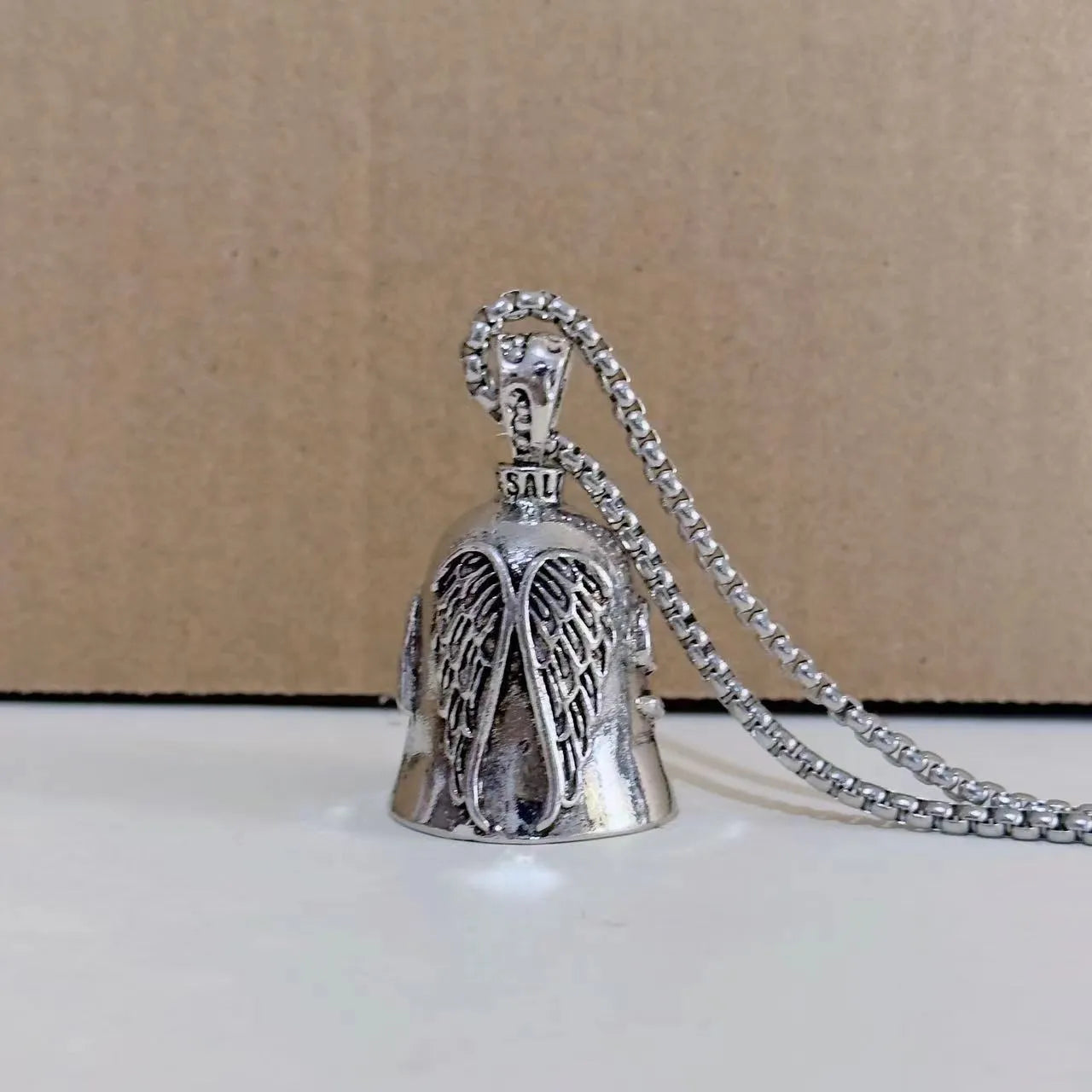 Vintage silver-tone angel wings feather keychain and necklace on a white background.