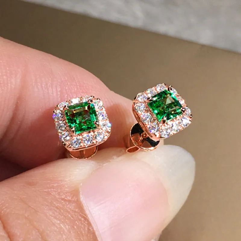 A pair of bright green square zircon stud earrings with a gold electroplated setting on a white background.