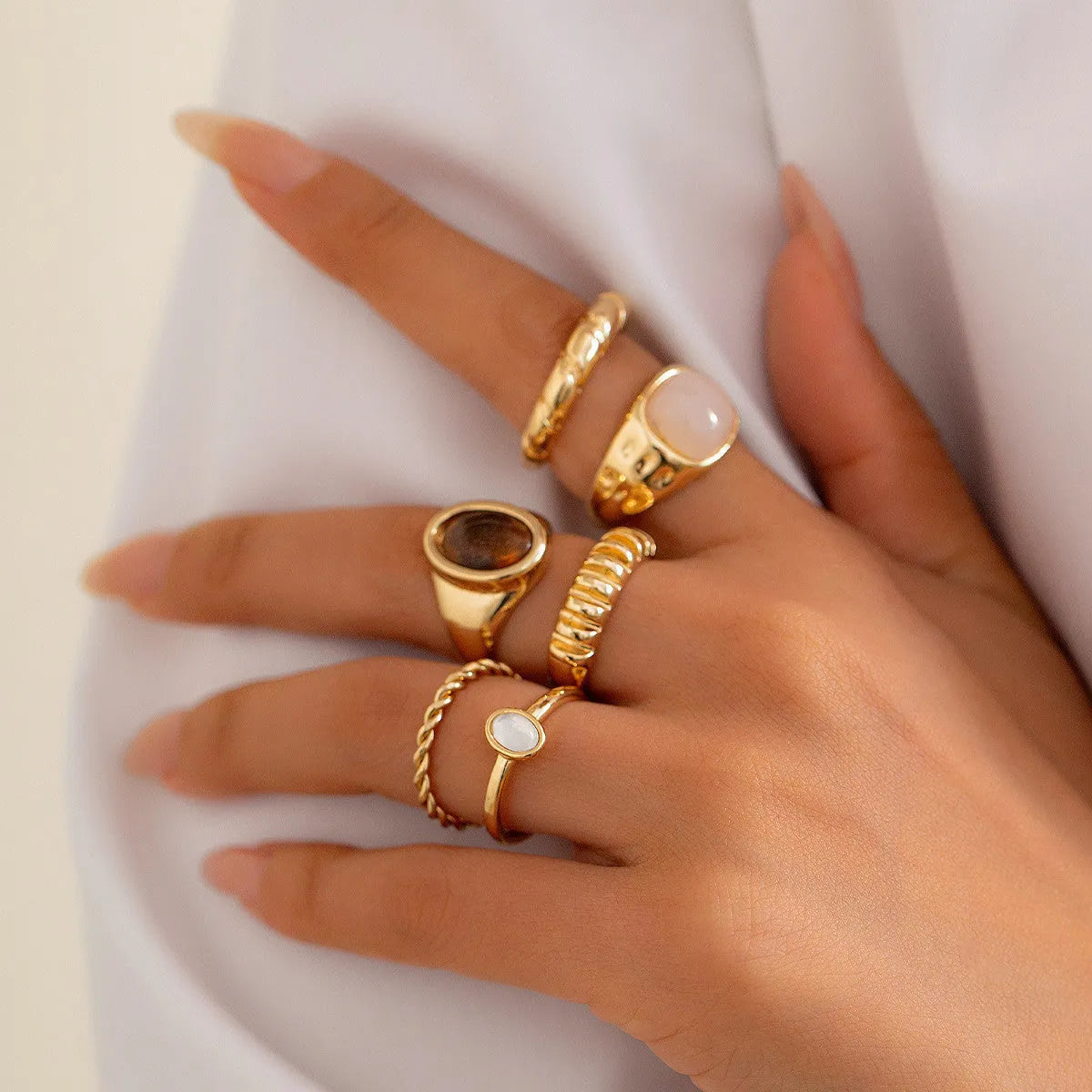 Six irregular geometric alloy rings with light gold electroplated finish arranged as a jewellery set