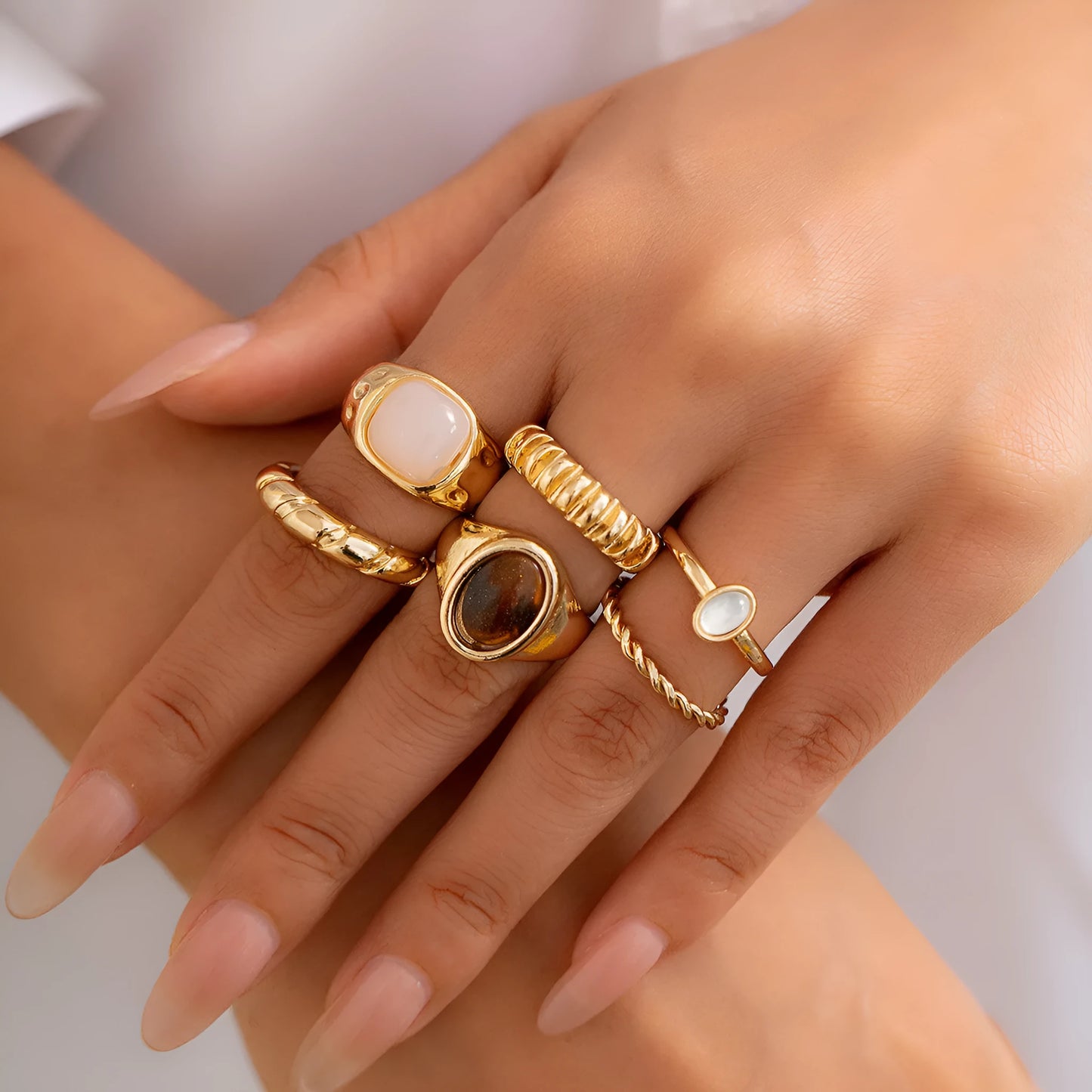 Six irregular geometric alloy rings with light gold electroplated finish arranged as a jewellery set