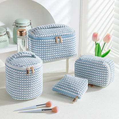 Four cube-style flannelette makeup bags in pink, khaki, pink dots, and blue with dots colours showing compartment organisation