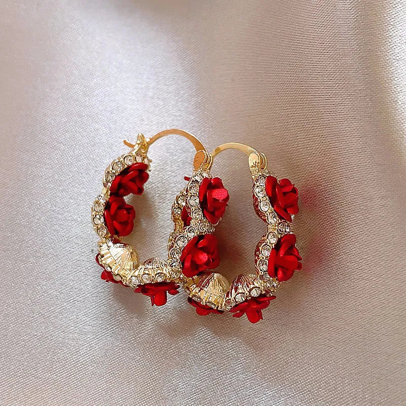 Red alloy rose flower earrings with ear clip fastening shown as complete pair