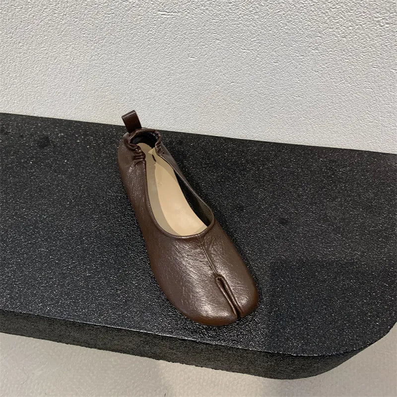 Women's black split-toe chunky heel pumps with round toe and low heel on a white background