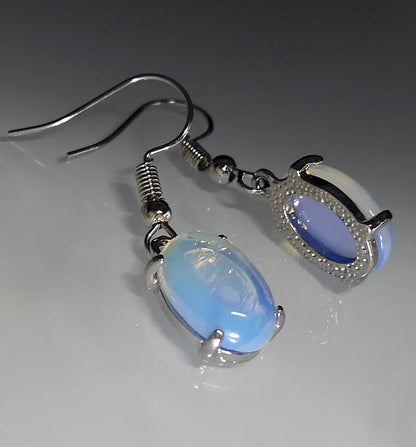 Opal earrings with electroplated alloy construction in moonlight white colour featuring drop shape design with ellipse elements and cross motif
