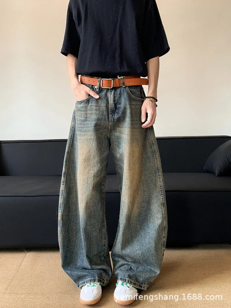 Man wearing retro blue distressed slim-fit jeans with a wide-leg cut.