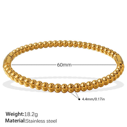 Stainless steel open-end bracelet with a buckle clasp in a gold electroplated finish featuring circle design elements.
