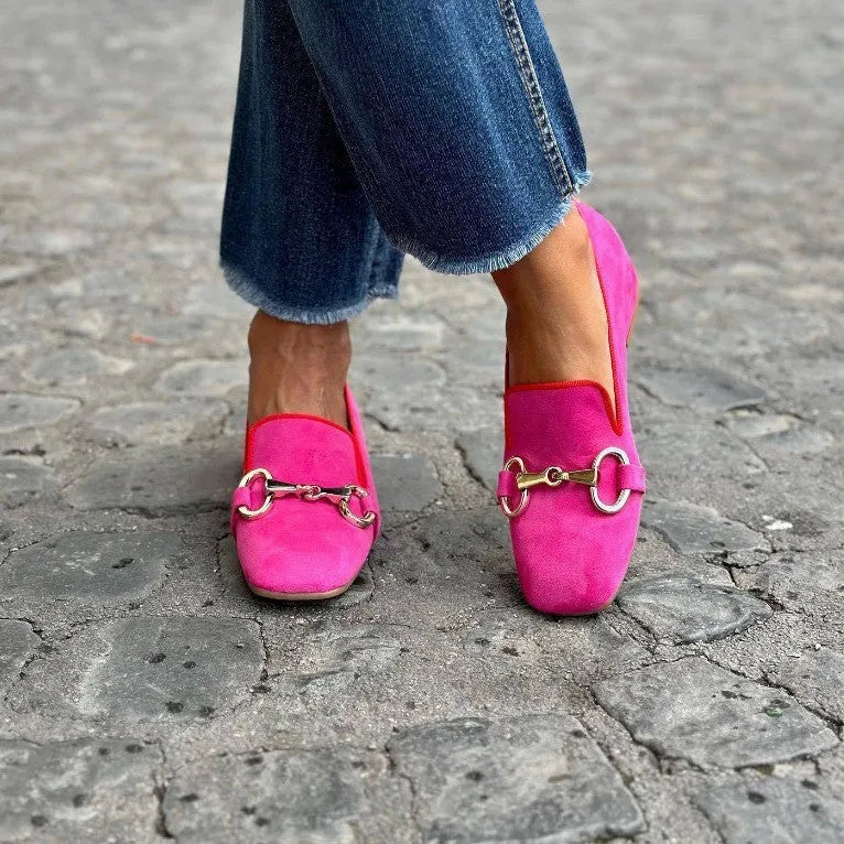 Green suede flat bottom loafers with a round toe, metal fastener, and low rubber heel.
