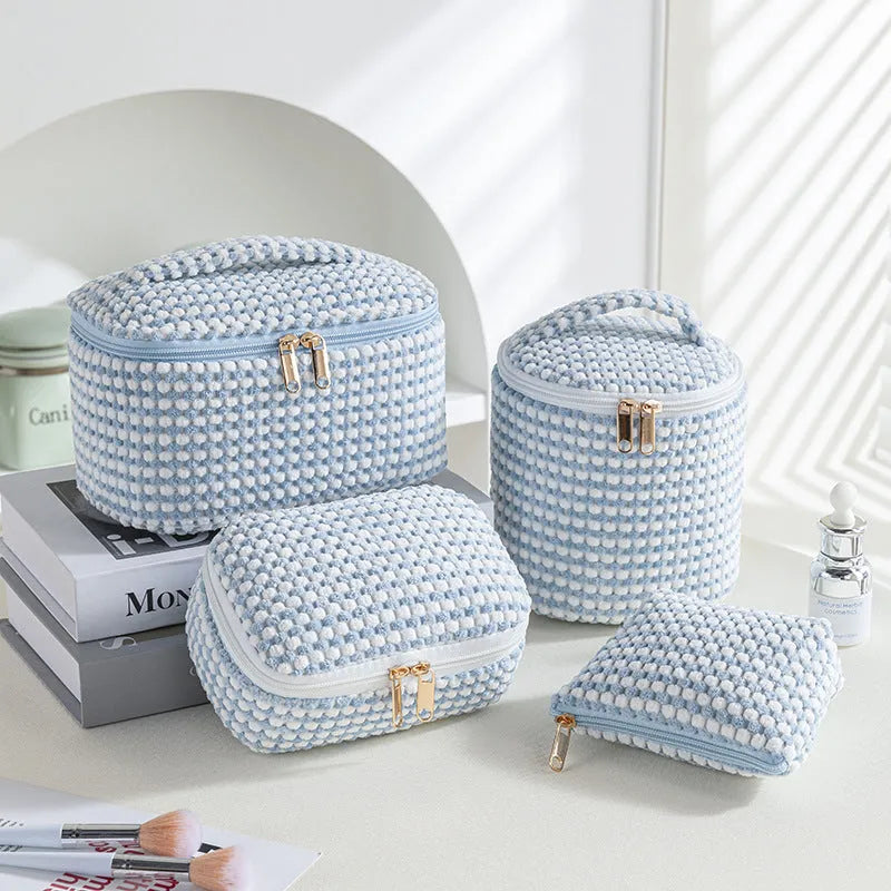 Four cube-style flannelette makeup bags in pink, khaki, pink dots, and blue with dots colours showing compartment organisation