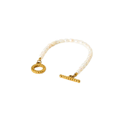 Freshwater pearl and geometric stainless steel necklace and bracelet set for women on a white background.