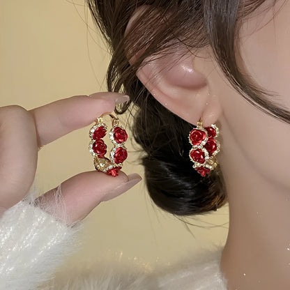 Red alloy rose flower earrings with ear clip fastening shown as complete pair