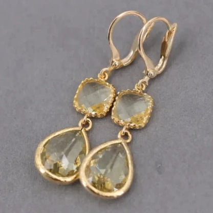 Gold geometric drop earrings with long crystal fringe and water droplet design.